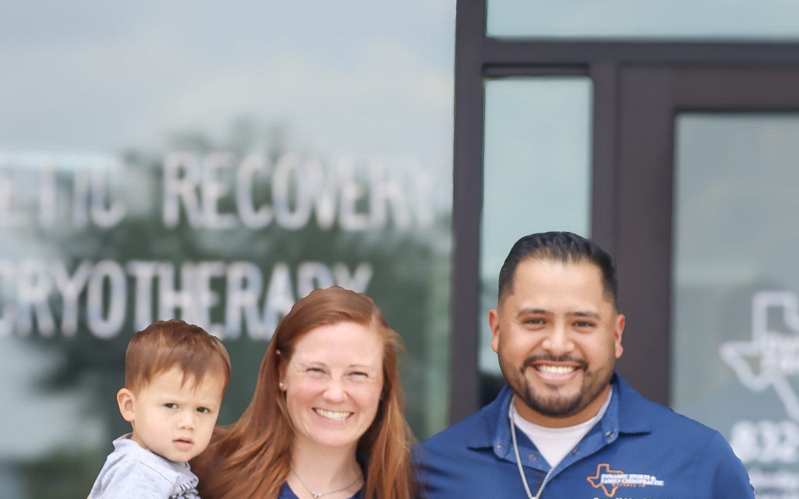 Dr. Bryan Valdez and Dr. Brittany Valdez with family outside Dynamic Sports & Family Chiropractic
